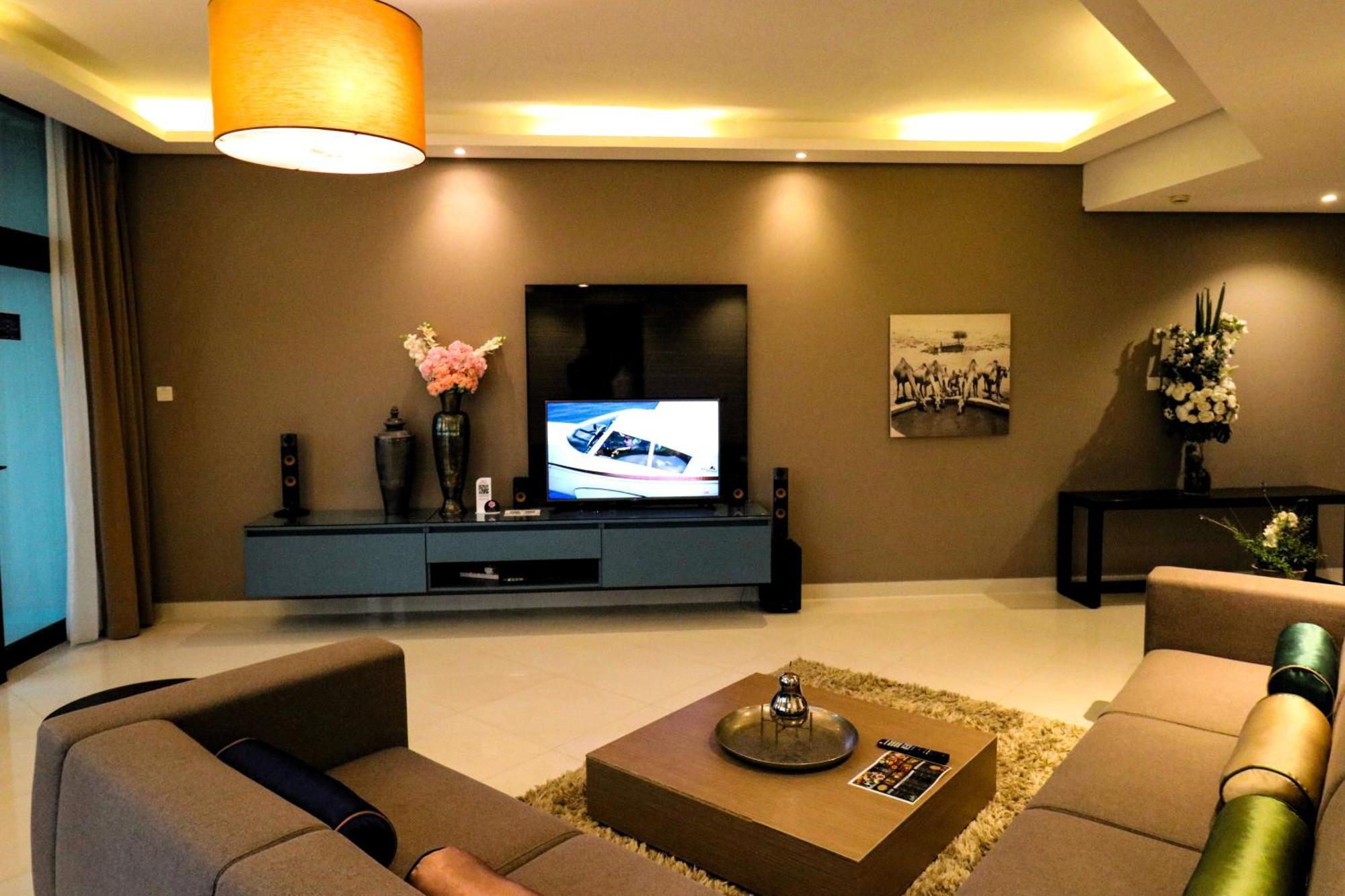 Lagoona Beach Luxury Resort And Spa Manama Exteriör bild The photo shows a modern living room with a neutral color palette. Key features include:

- A comfortable seating area with a sofa arranged around a coffee table.
- A minimalist coffee table with a decorative item on top.
- A large flat-screen televi